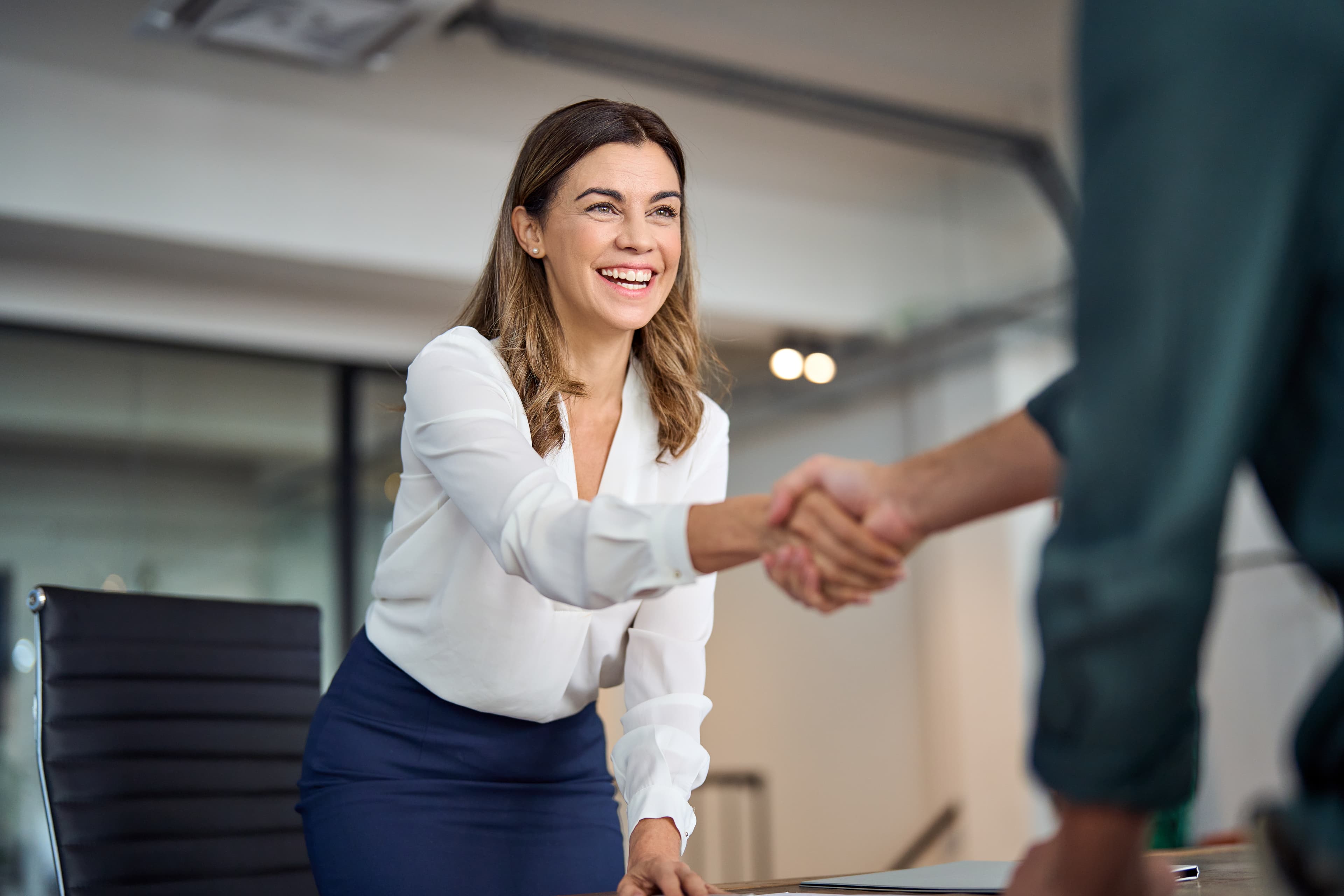 Woman in a business suit shaking hands with a man