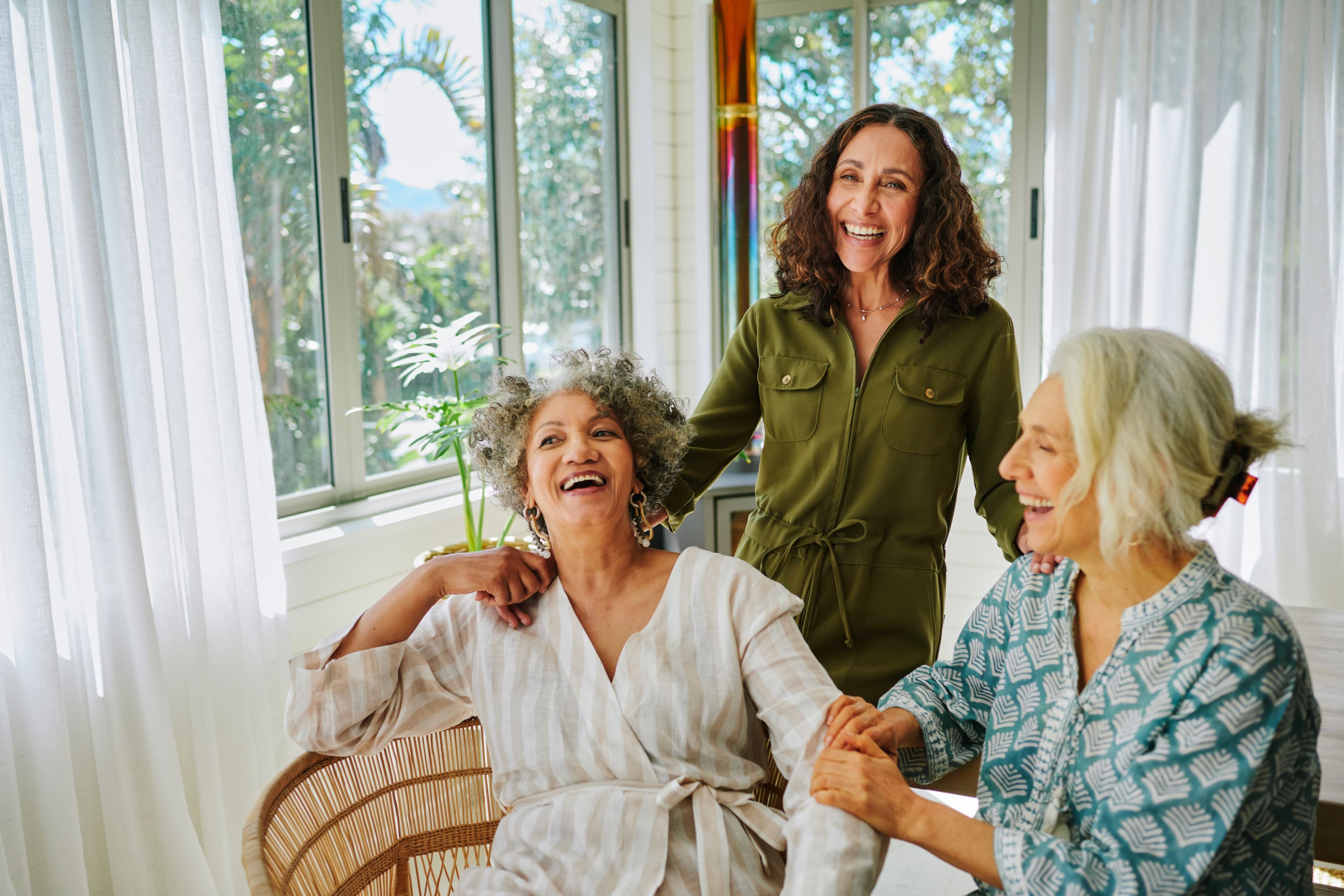 Two women sitting and one standing behind them