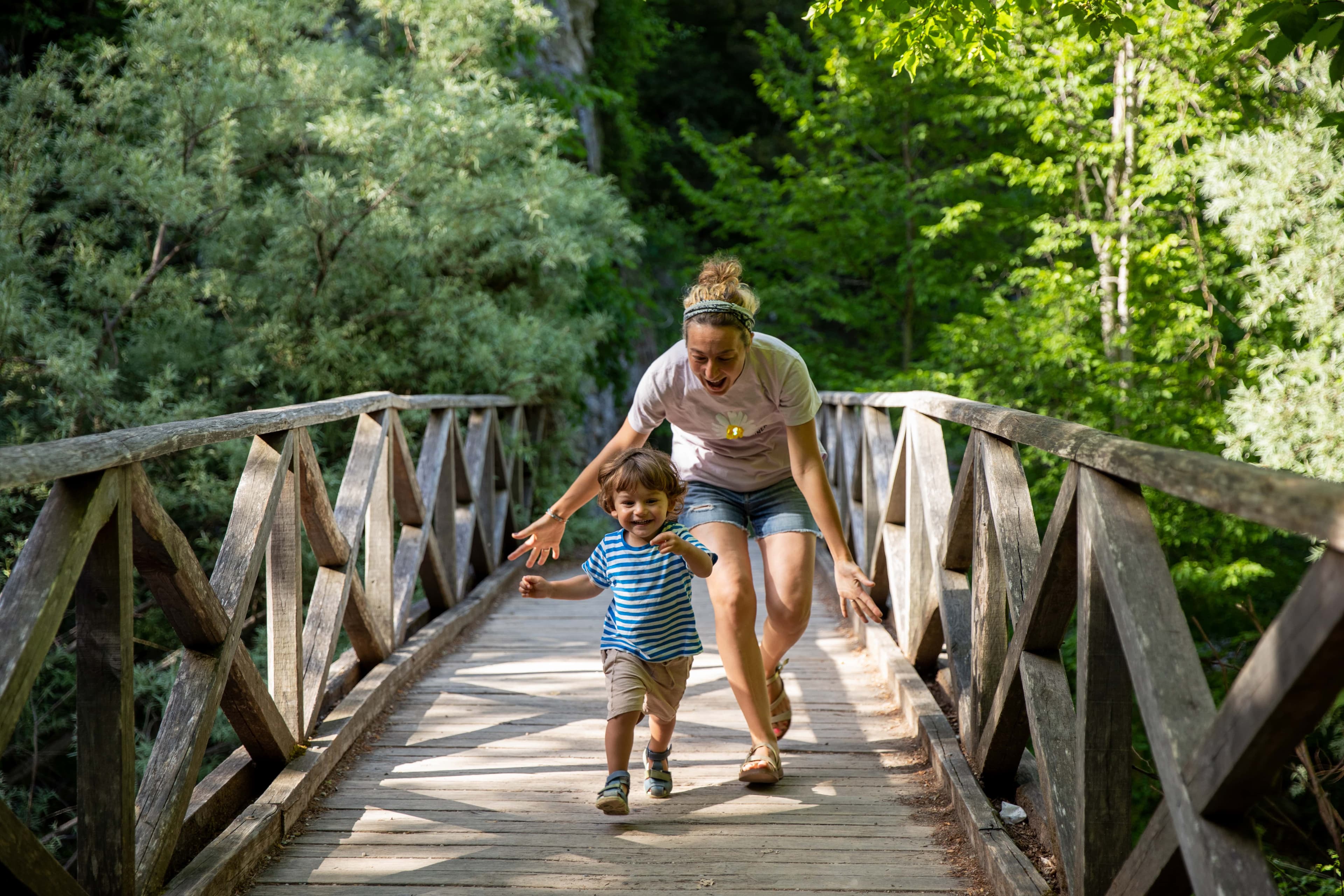Woman on a bridge playing with her son